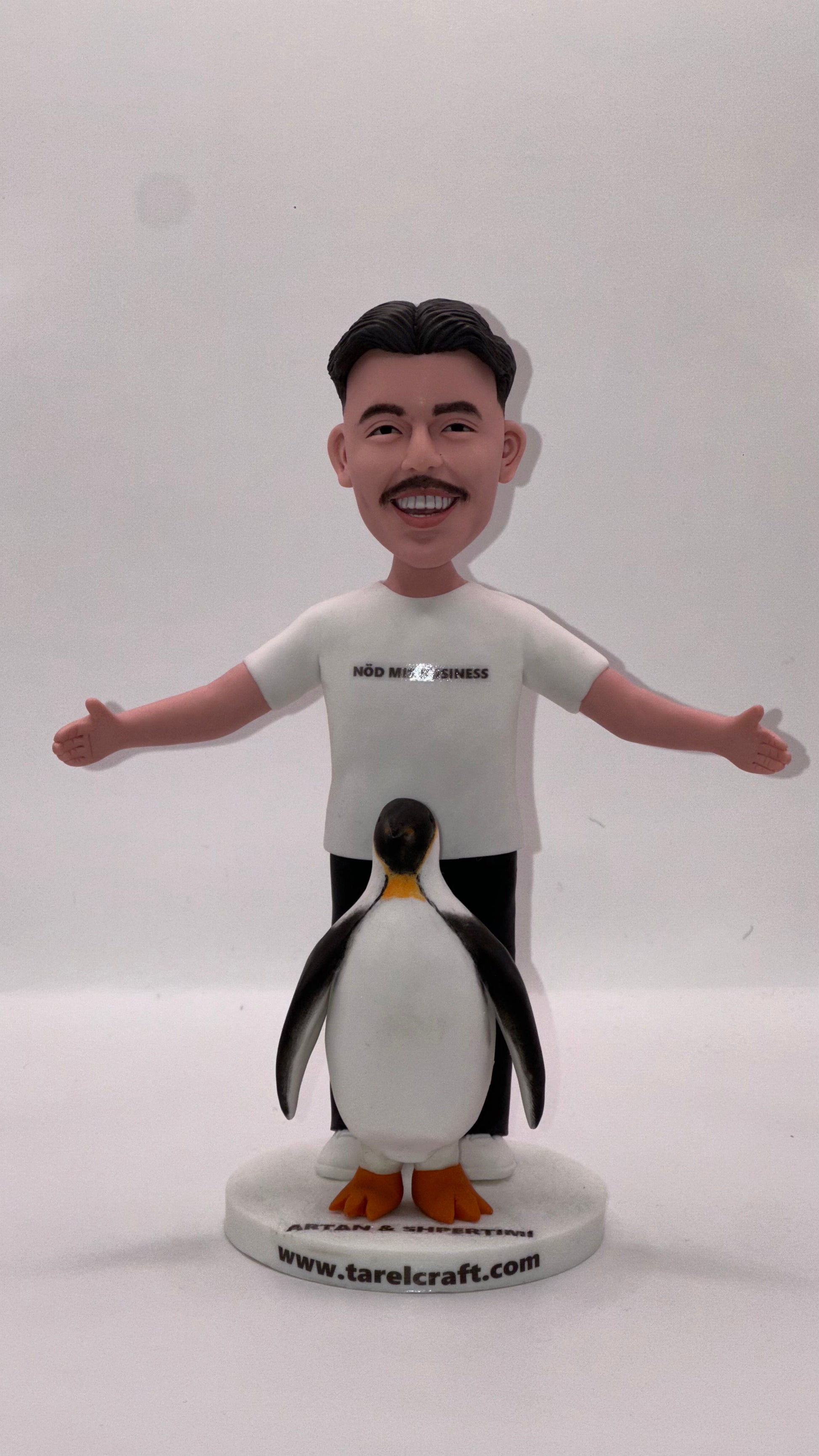 Smiling man bobble head with penguin